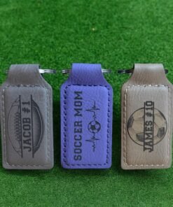Three engraved vegan leatherette keychains in gray, purple and tan colors