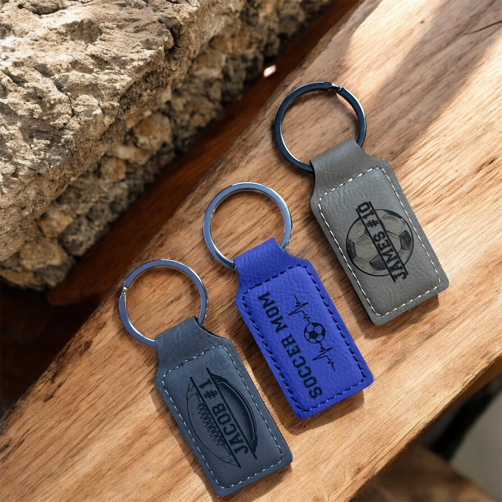 Gray and purple engraved vegan leatherette keychains with football and soccer designs
