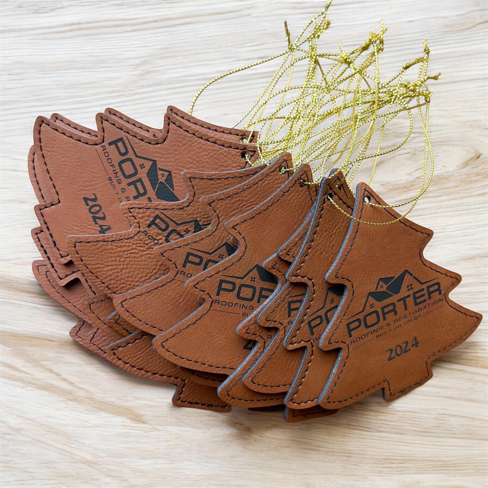 Brown leatherette Christmas tree ornaments engraved with a sample business logo