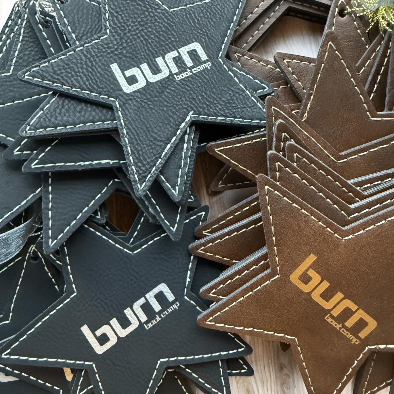 Black and brown leatherette star ornaments engraved with a sample brand logo