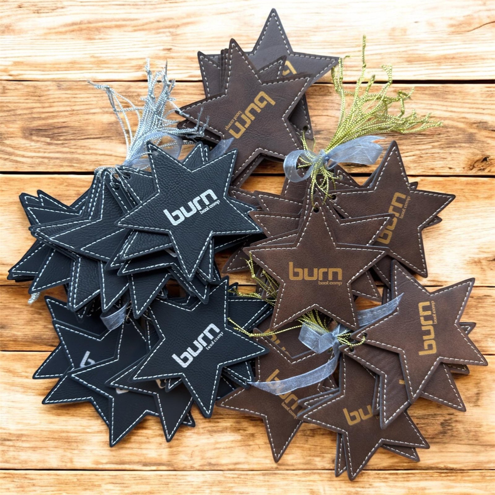 Black and brown leatherette star ornaments engraved with a sample business logo