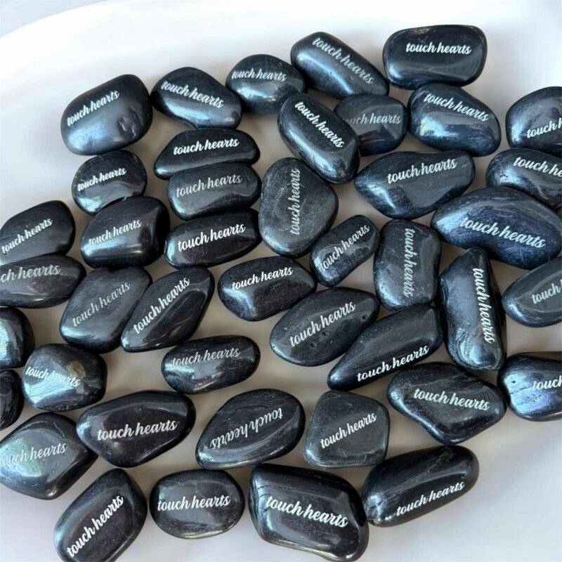 Engraved river rocks with custom message about touching hearts